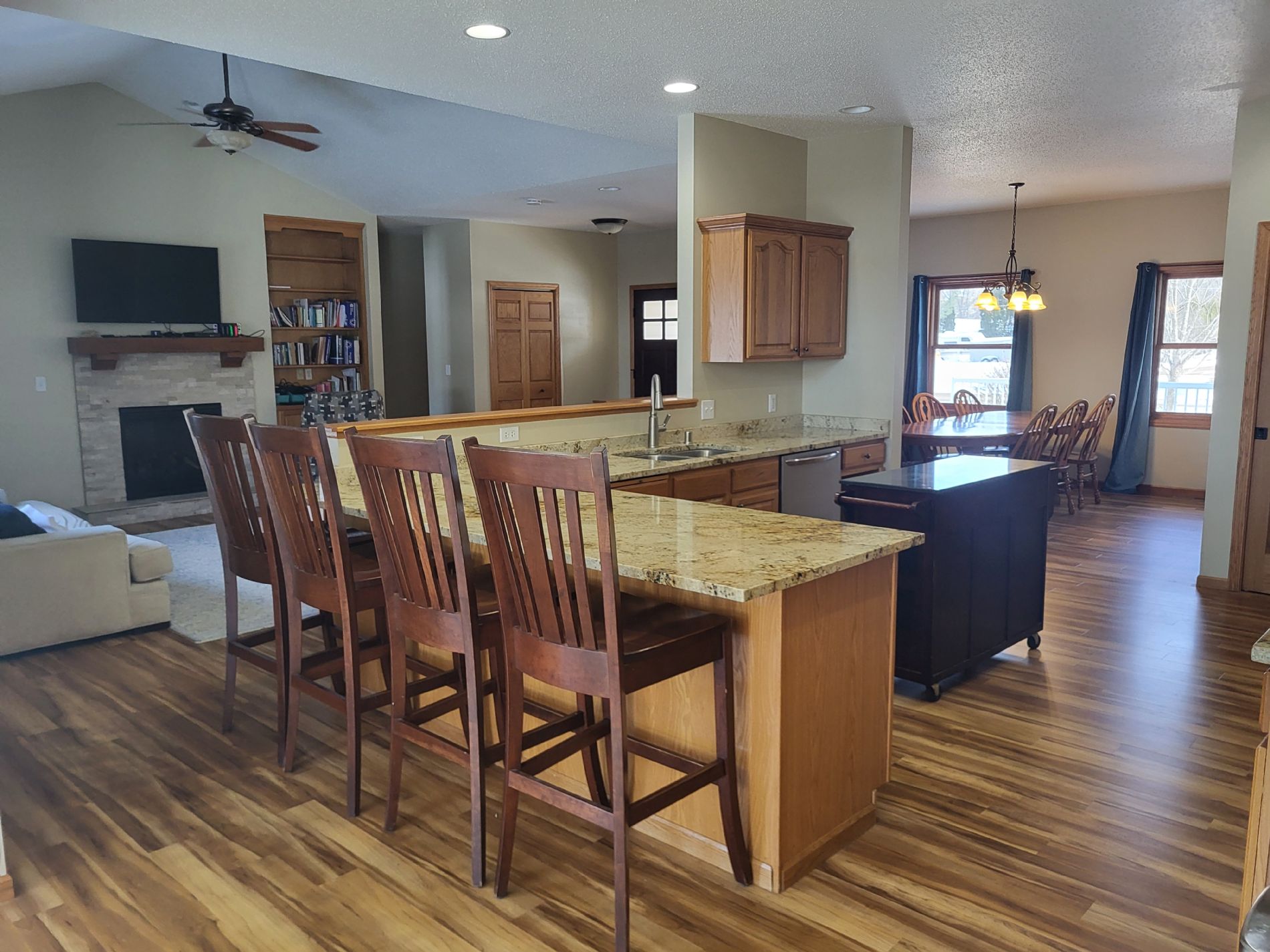 Peninsula bar, chef's kitchen with granite countertop, and views to the great room and dining room.