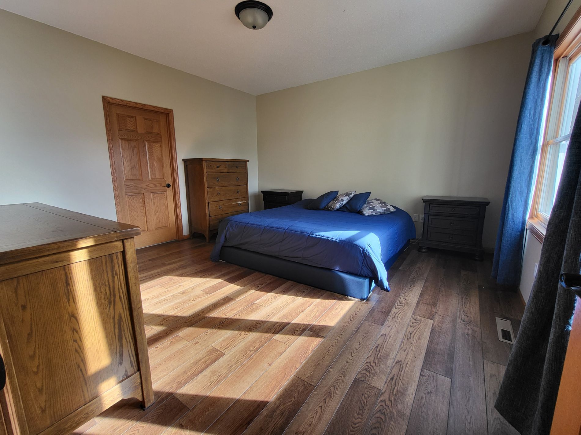 Master bedroom with beautiful Smartcore floors, outdoor views, and master bathroom access.